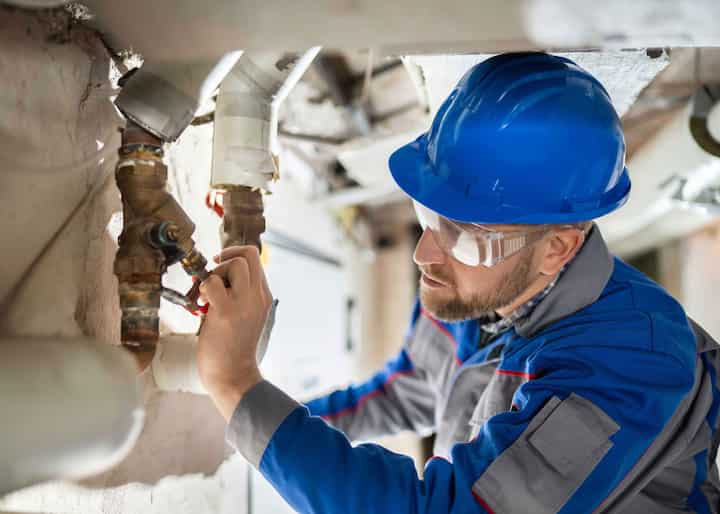 water repair expert fixing a pipe in Queens, NY